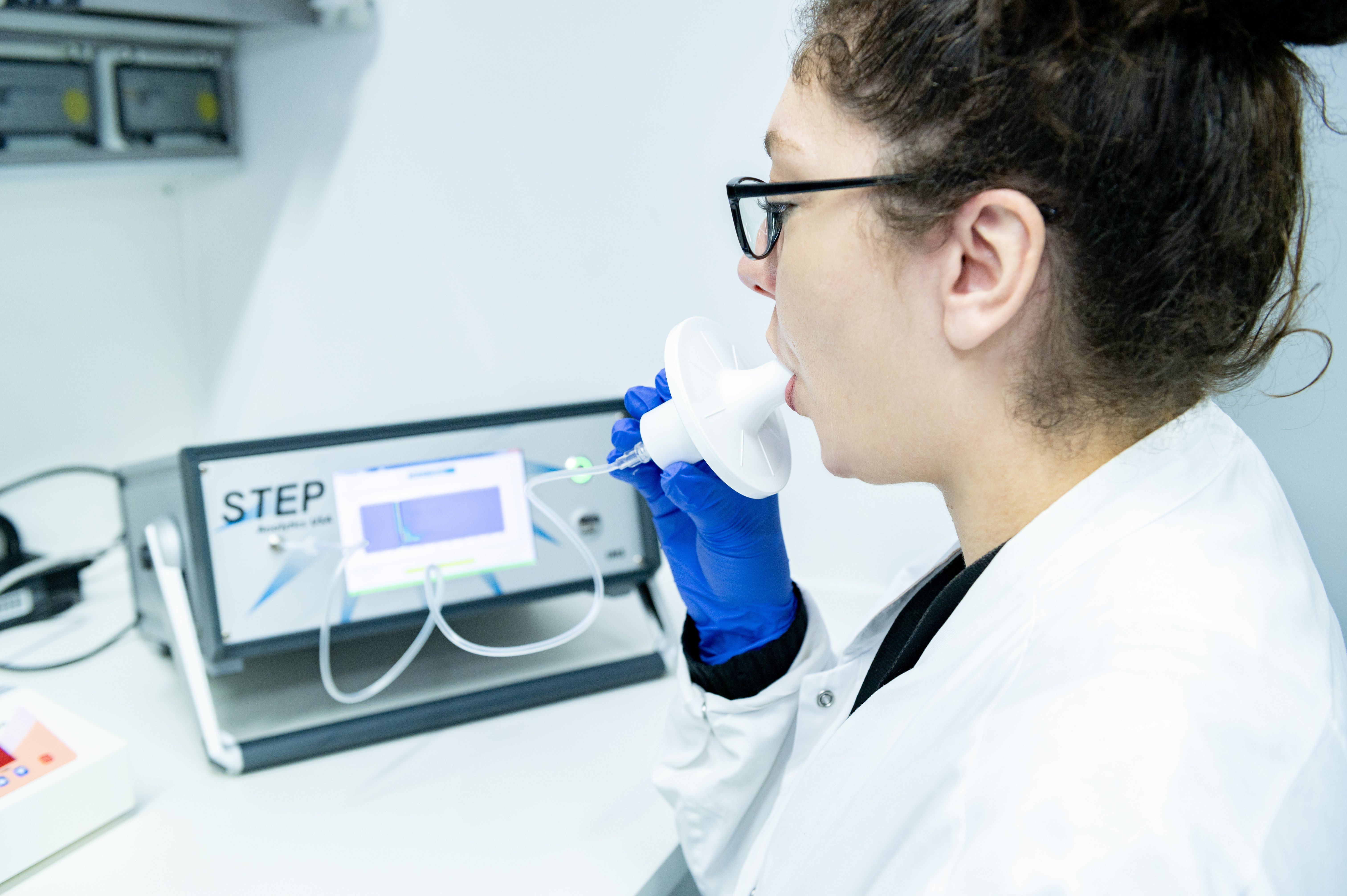 Wissenschaftlerin atmet in ein Gerät um ihren Sauerstoff zu untersuchen