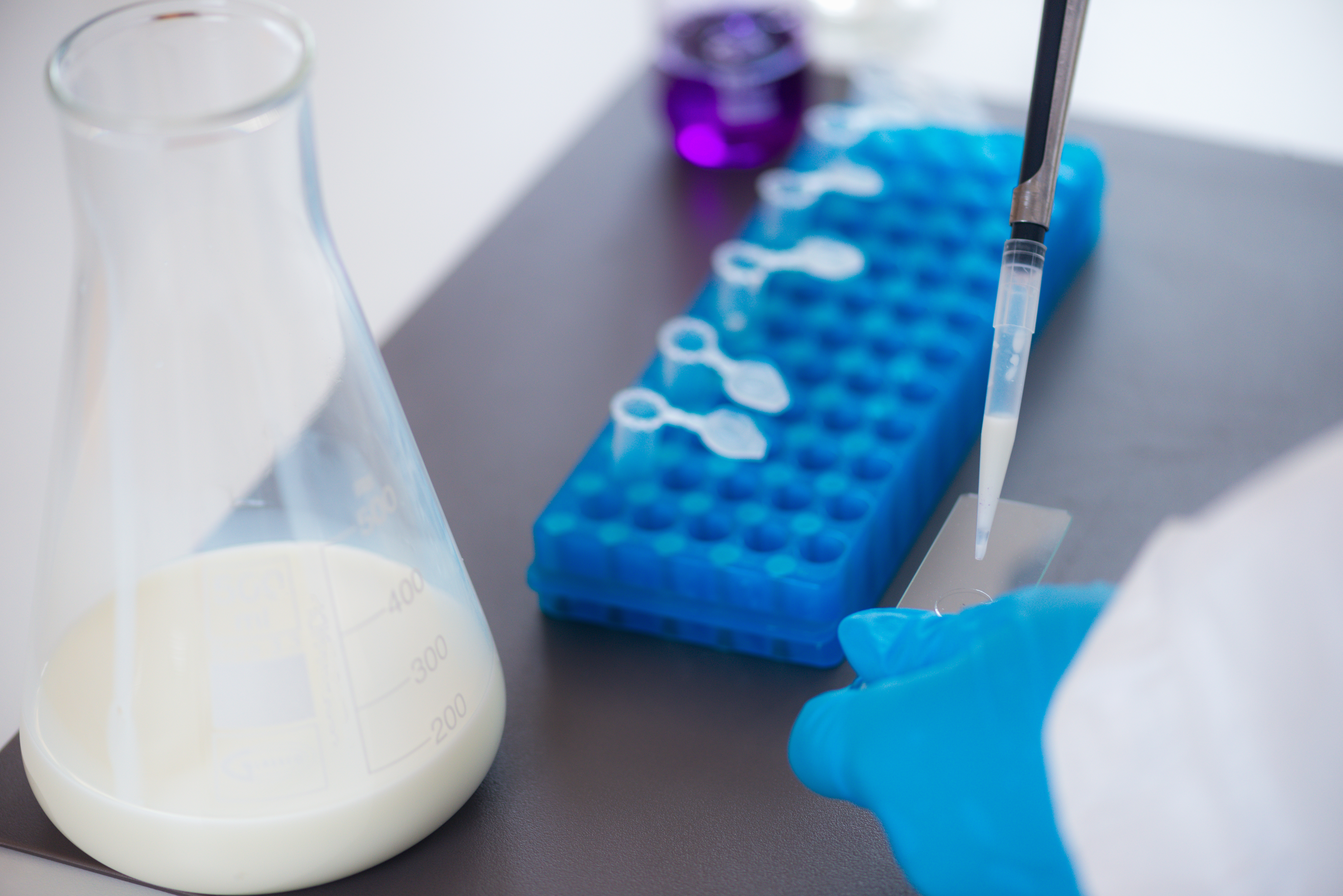 A white liquid is pipetted in a laboratory.