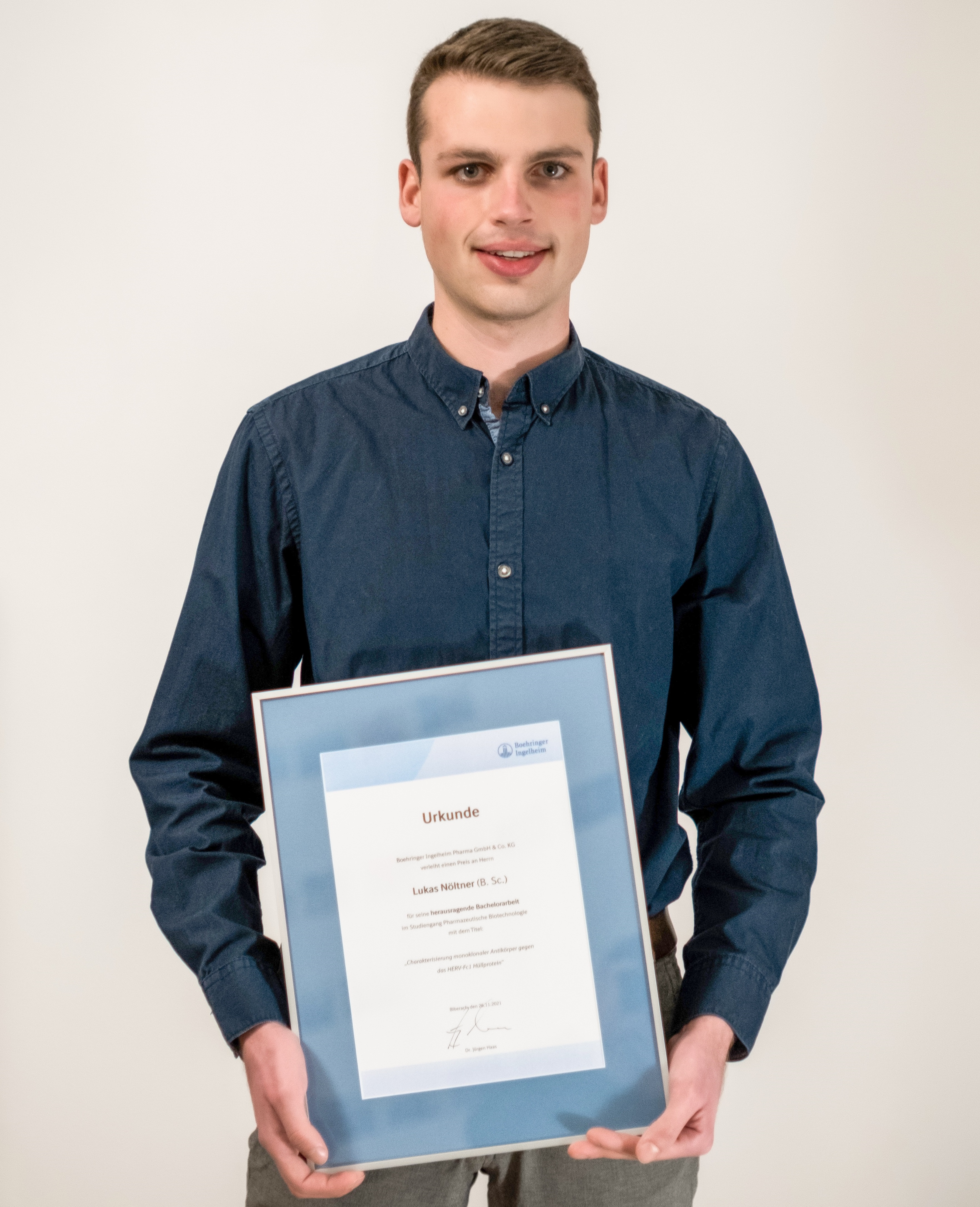 Lukas Nöltner standing with certificate