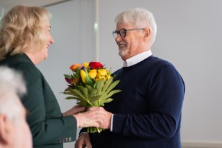 Professor Ulrike Köhl presents flowers to Professor Hans-Ulrich Demuth.